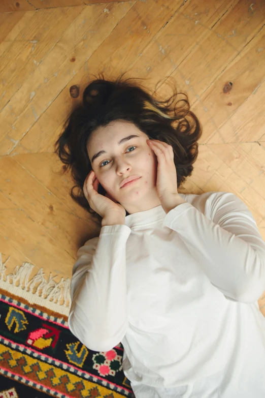 a young woman laying on the floor with her hand under her head