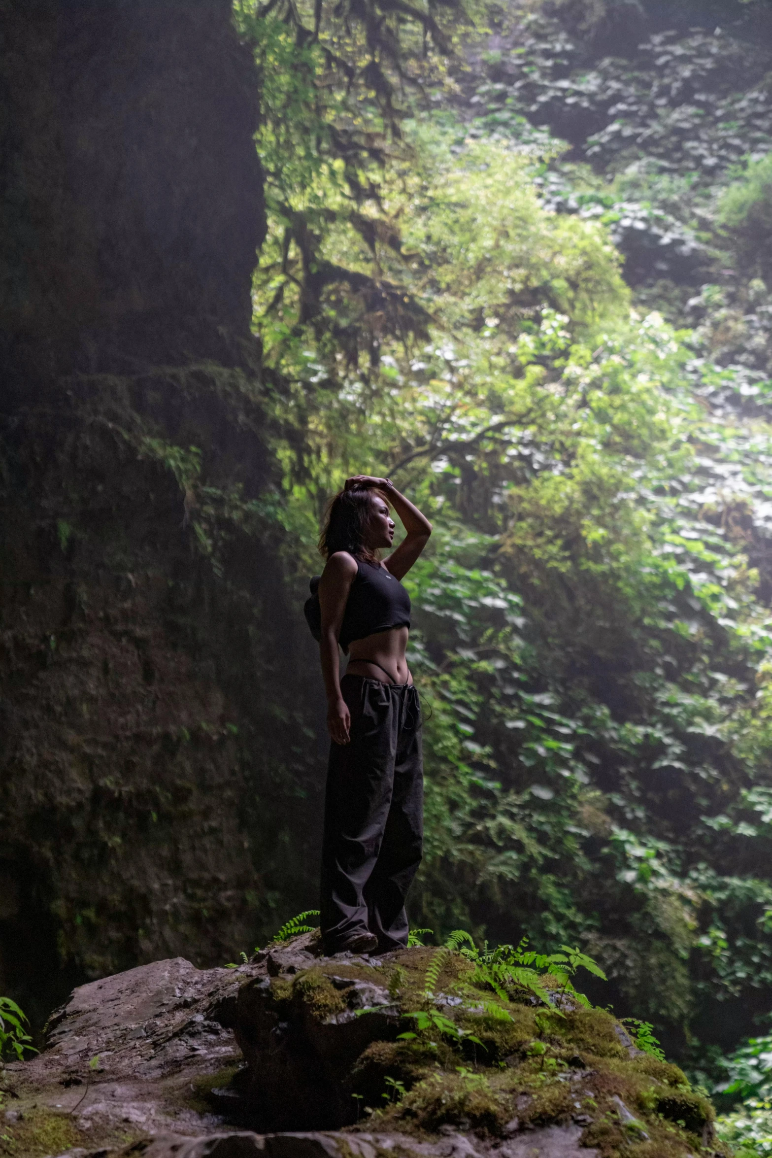 a woman standing on a rock in a forest