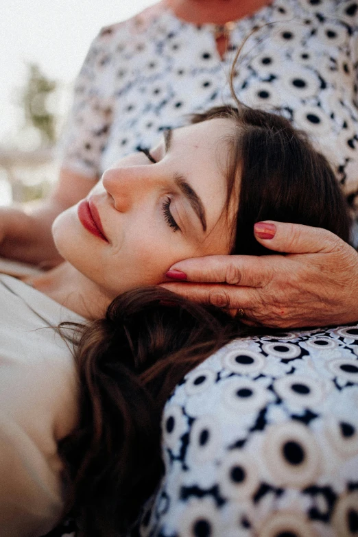 a woman laying down and touching her face