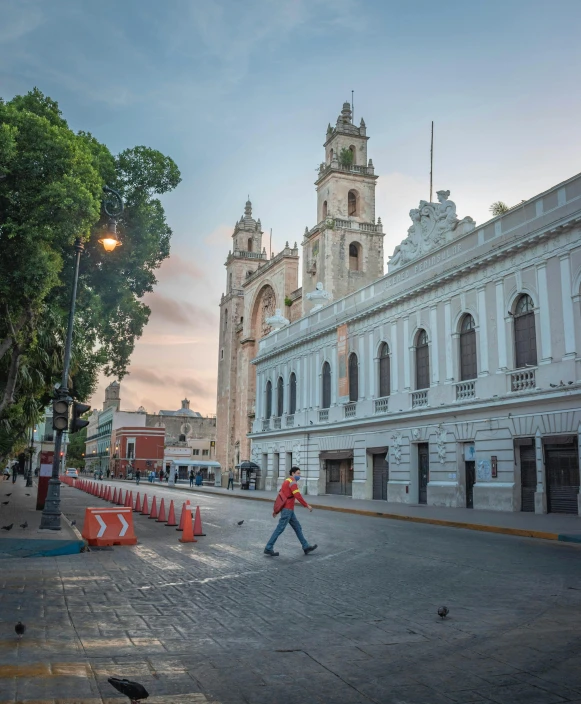 a man is walking down the street past the cathedral