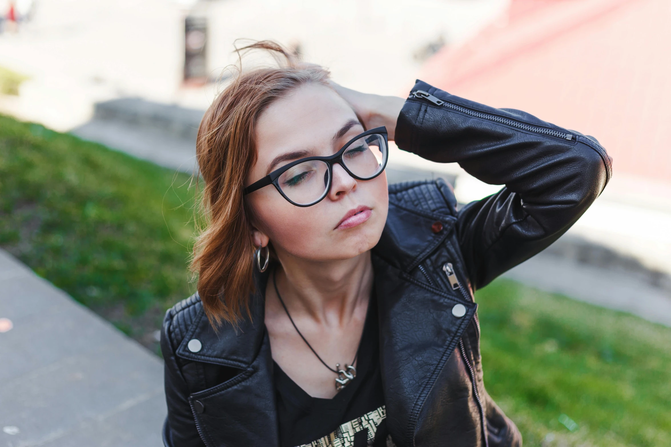 a beautiful young woman in black leather jacket and glasses