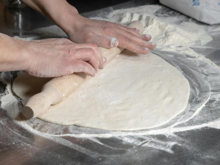 a hand is putting some dough on top of the dough