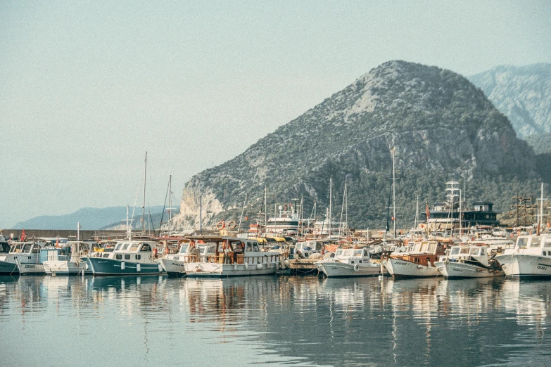 a boat dock on the side of a mountain with boats parked on the water