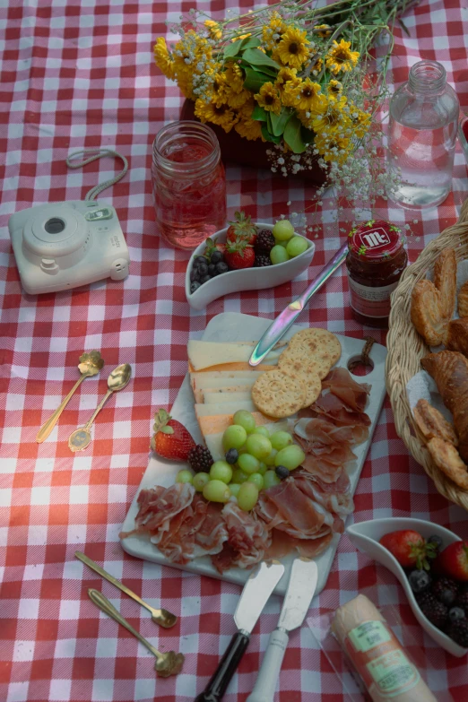 a table full of wine and breads, bread sticks, jam, nuts, gs, and strawberries