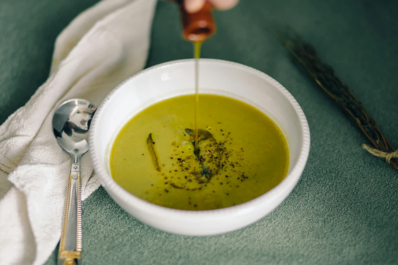 the bowl is full of soup and has a spoon in it