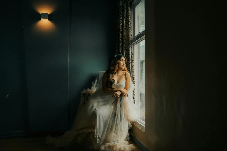 a woman is sitting on a windowsill with a bouquet