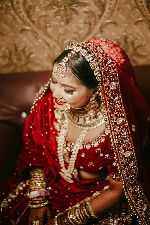 a woman in a wedding outfit sitting on a brown couch