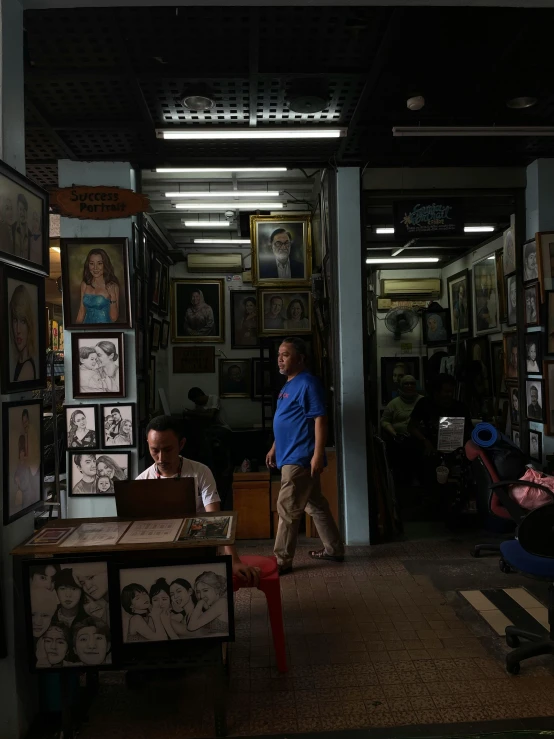 a person sitting down in a store by another person