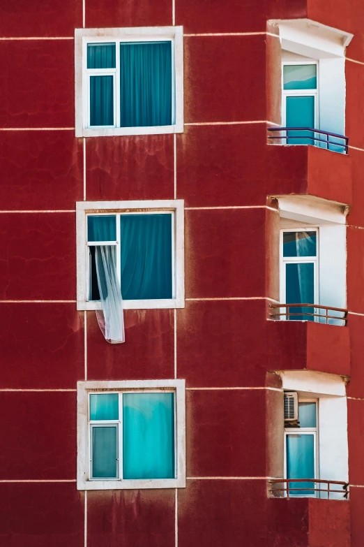 a bright red building with three windows and a balcony