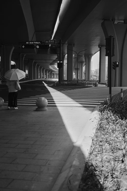 a person walking down the sidewalk with an umbrella