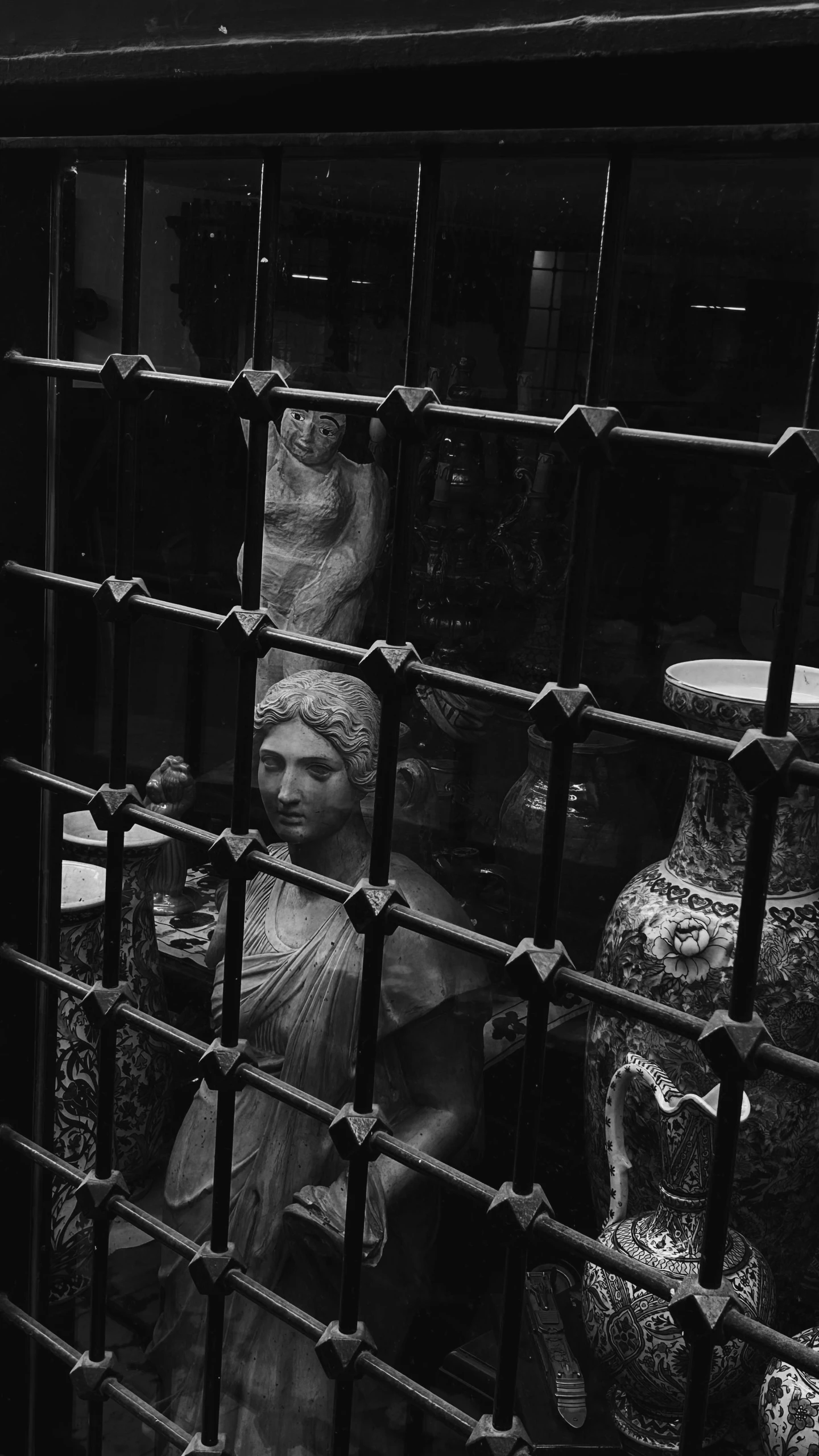 a woman behind the bars of a metal gate