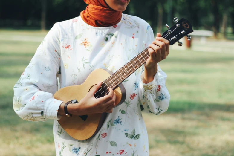 a woman is holding an acoustic instrument in her hands