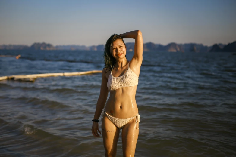 a girl stands in a bikini by the sea