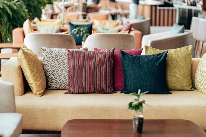 the colorful pillows are arranged on the couch