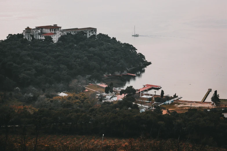 a house on the shore sits above the trees