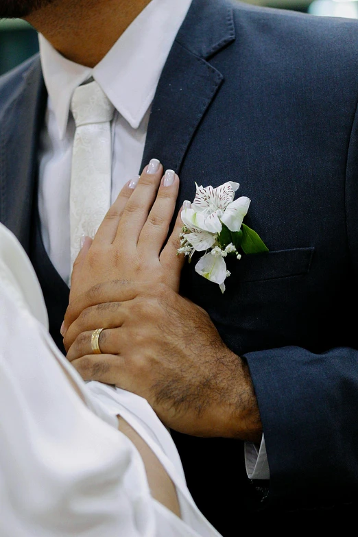 the bride is holding the groom's hand