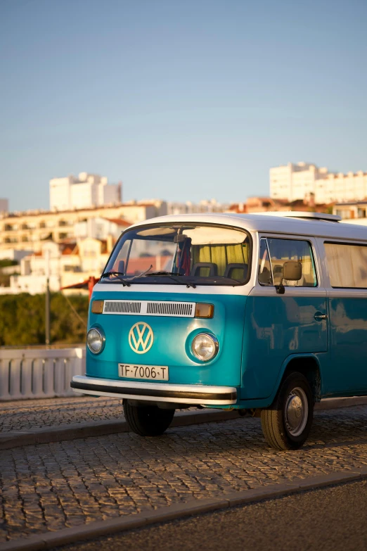 a blue and white van driving down a brick street