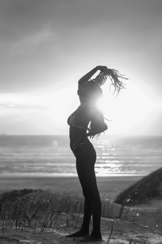 a woman with sun shining in her hair on the beach