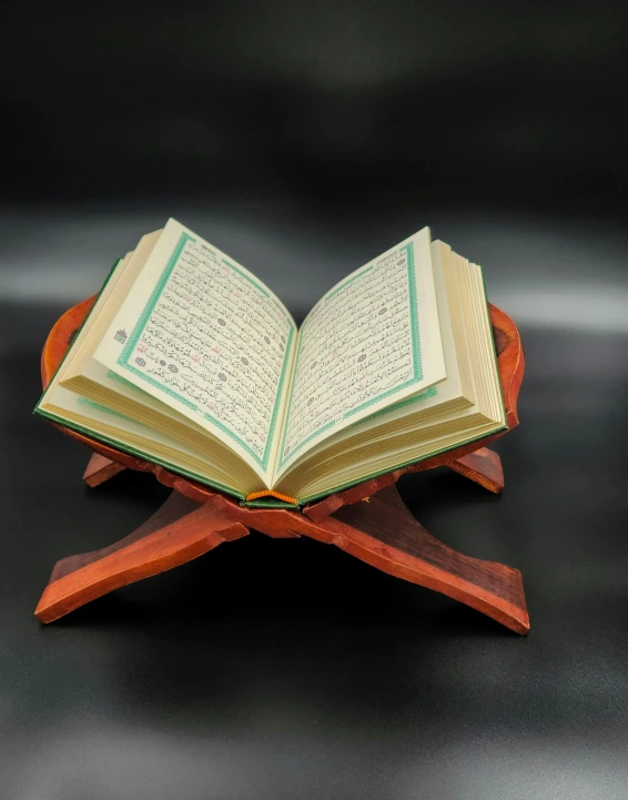 a wooden stand holding an open book with arabic writing