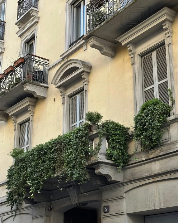 a tall brown building with several planters hanging off it's windows