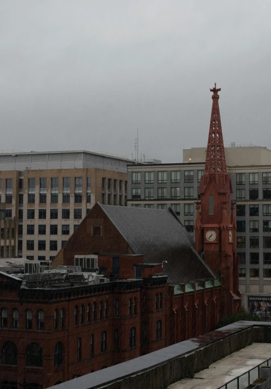 view of rooftop with clock and building with buildings on the other side