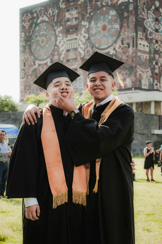 two graduate pose for a picture together