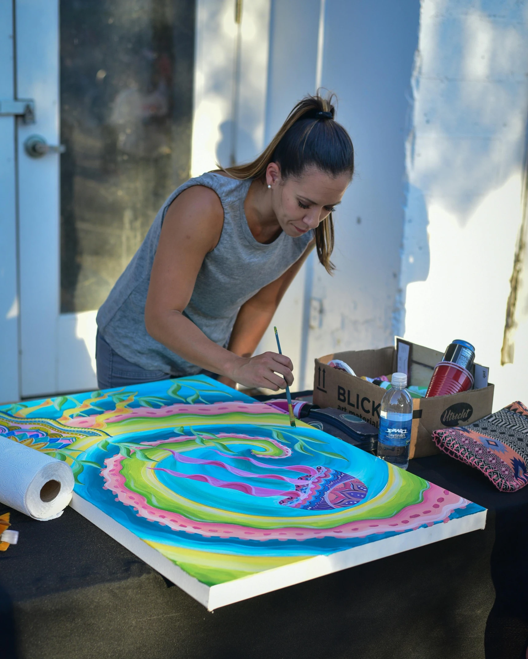 the lady draws on a giant painting on the floor