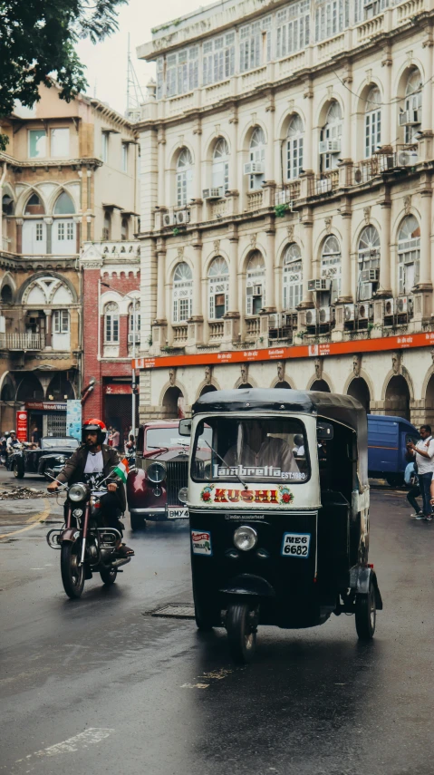 a street with a small van and a motorcycle riding in front