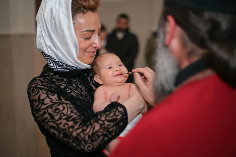 a woman is holding a baby and smiling