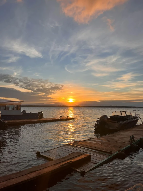 boats sitting on the dock in front of the sun