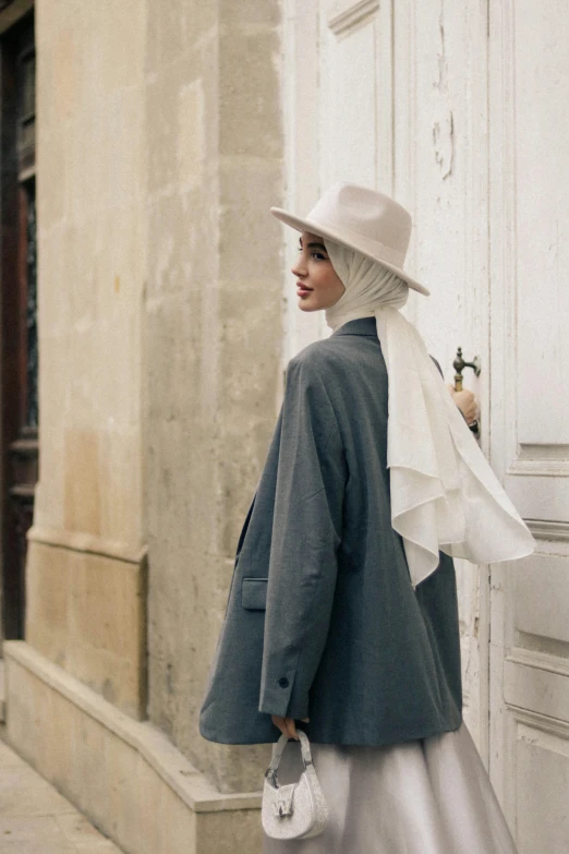 a woman wearing a long silver skirt and a white hat