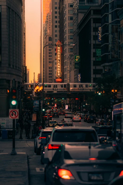 a busy city street at dusk in the middle of tall buildings