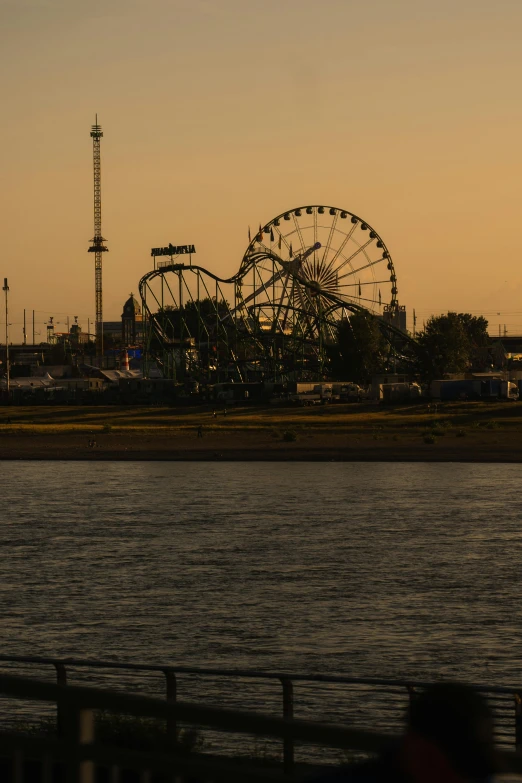 the ferris wheel of an amut park is by the water