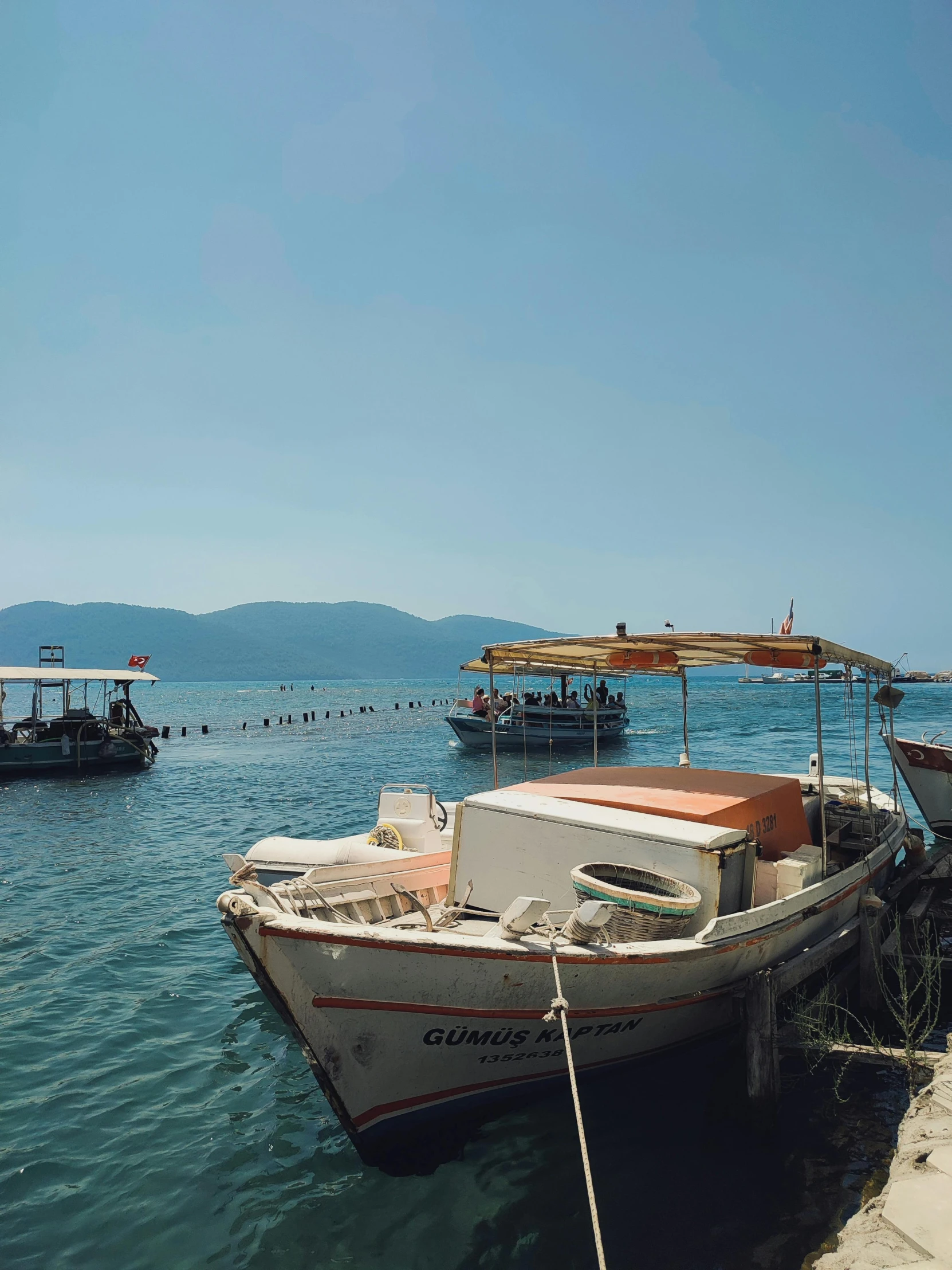 three boats sitting in the water by shore line