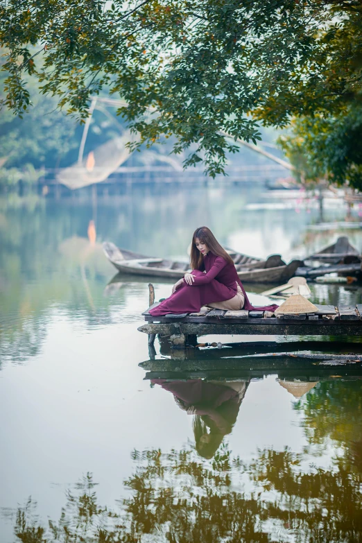 a woman sitting on the end of a boat on water