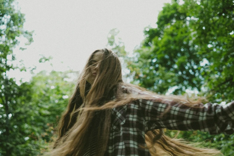 woman with hair up dancing through trees