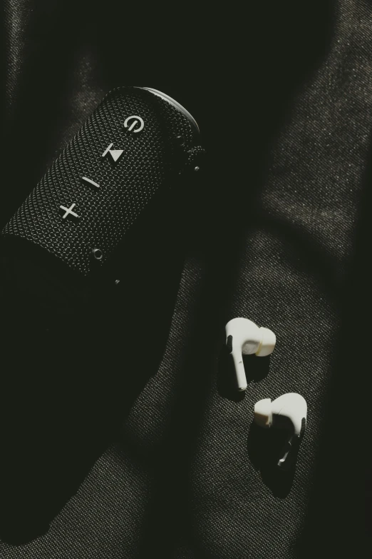 two ear phones sit next to a remote control