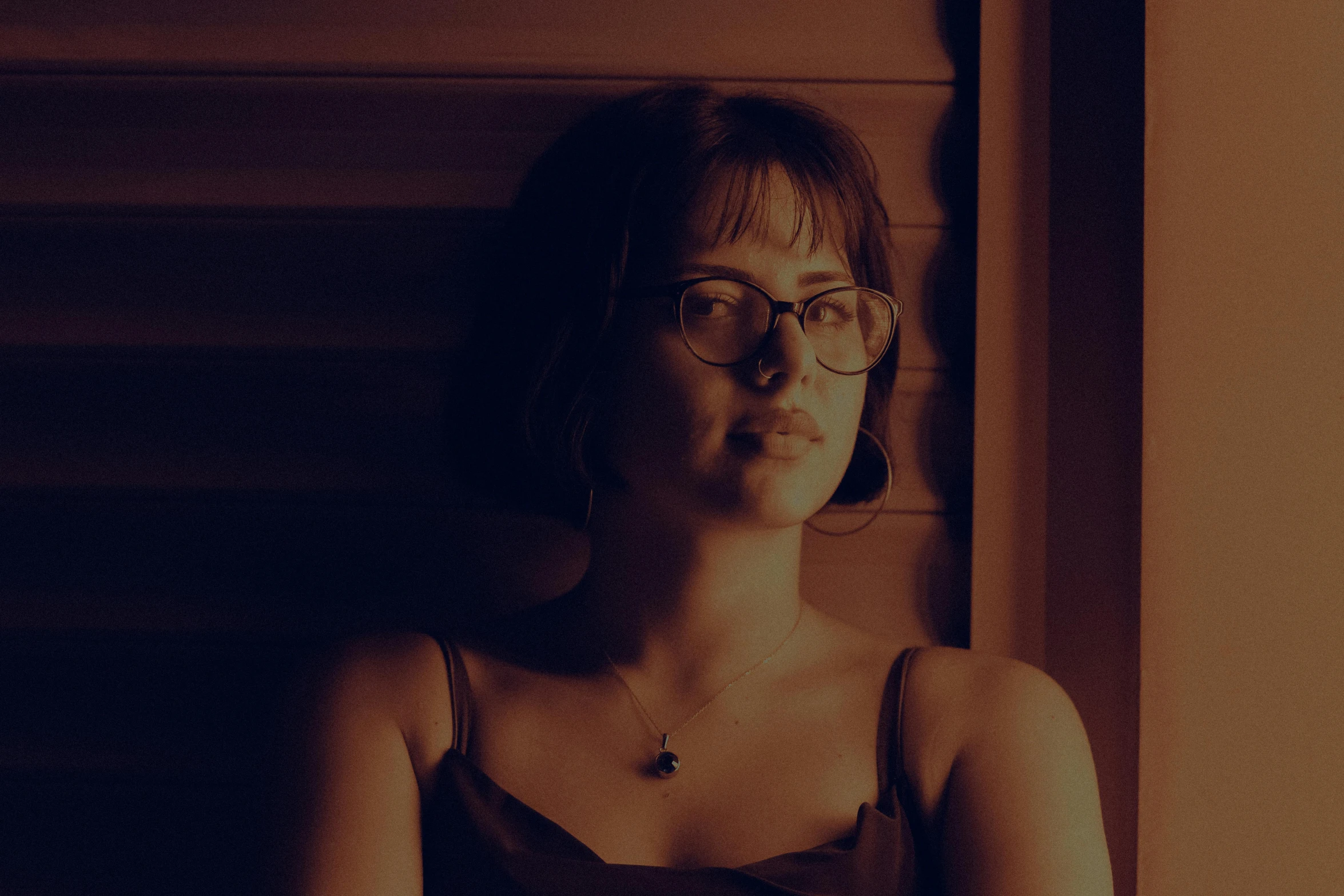 a woman wearing glasses and a tank top sitting in a chair