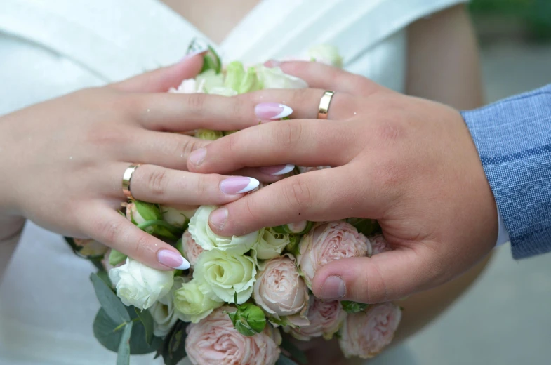 a bride and groom holding bouquets of roses