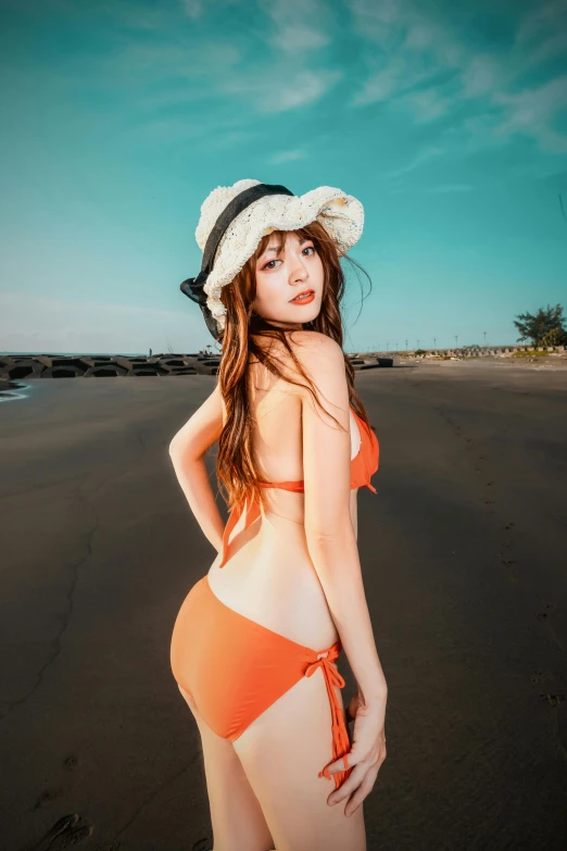 young woman in a hat standing on the beach