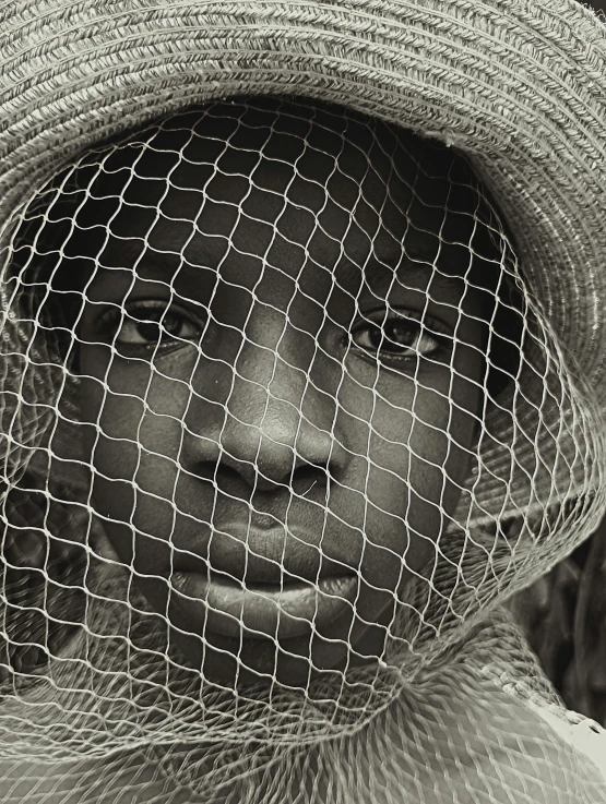 a woman wearing a veil and hat on top of her head