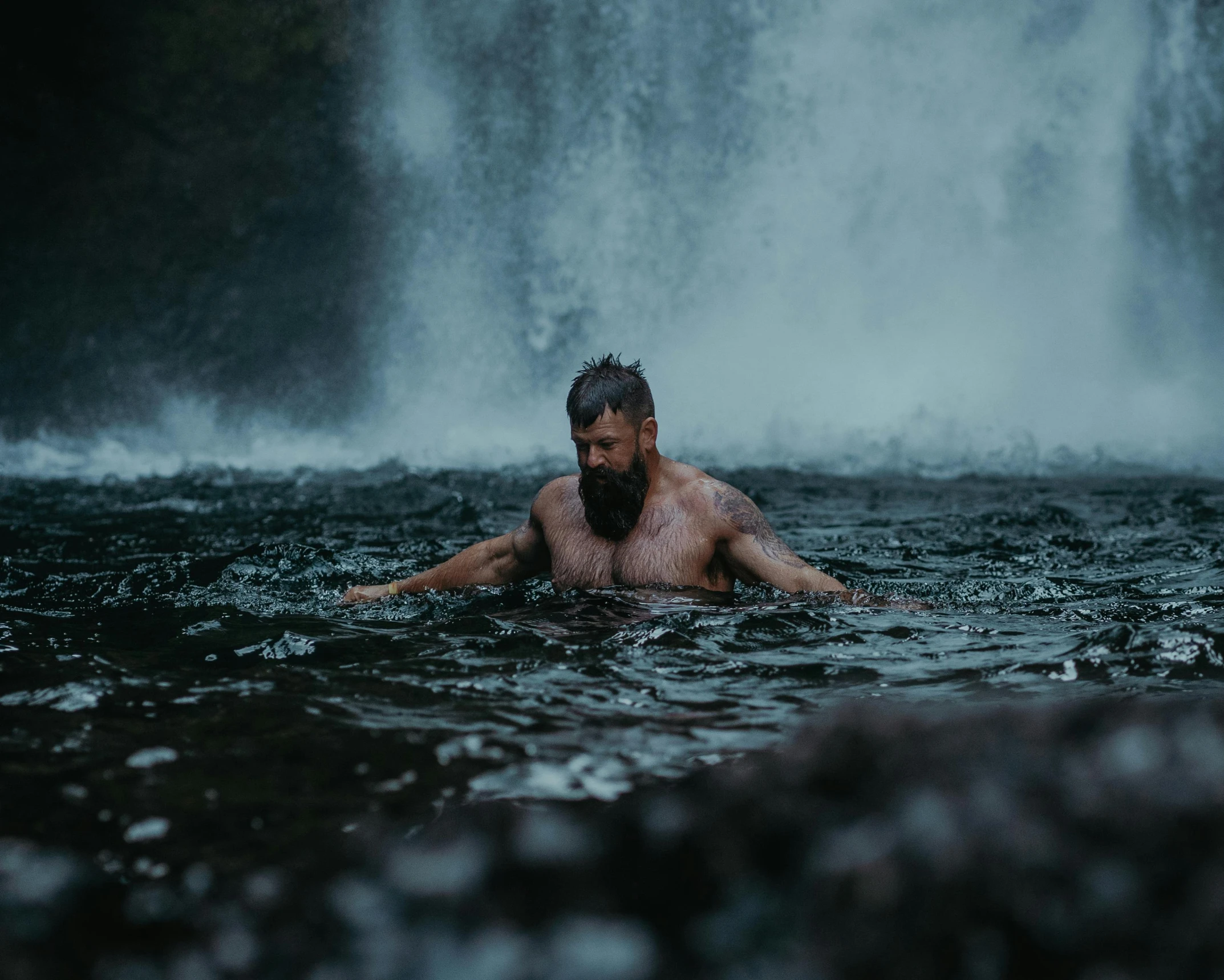 a man swimming in the water with his arms over his hips