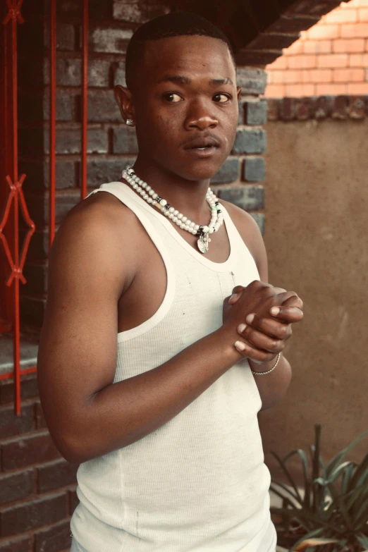 an african man in a white shirt and jewelry