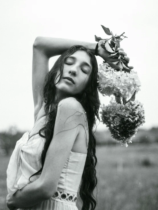 a young woman holding flowers near her face