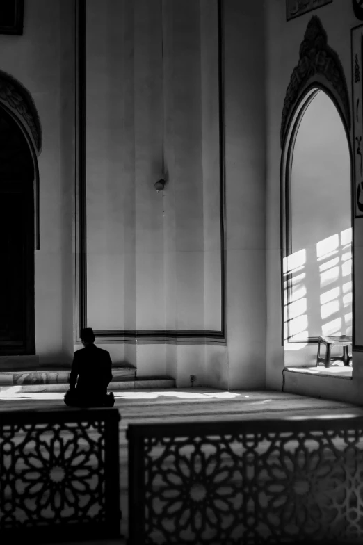 black and white image of a man sitting on a bench