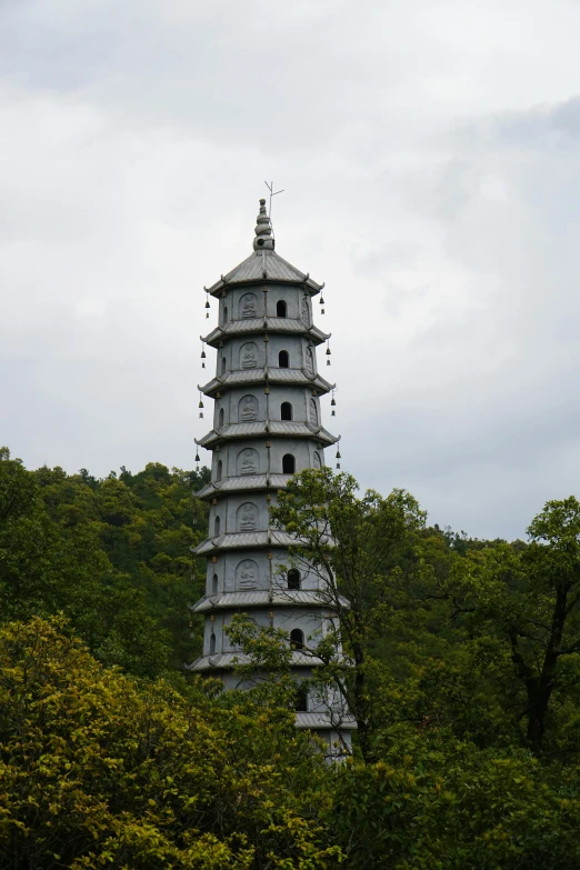 a tower surrounded by trees with an umbrella attached