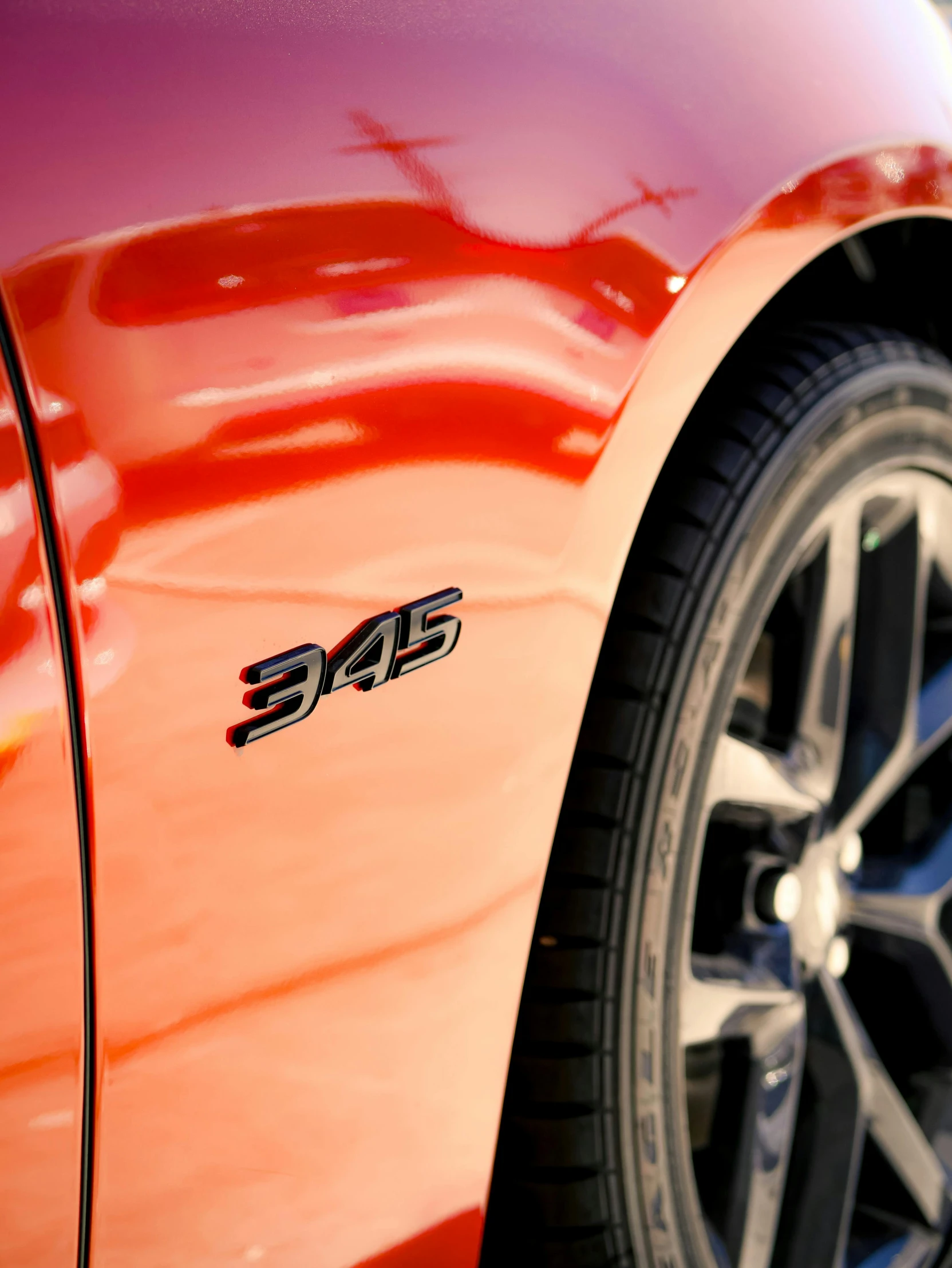 an orange car parked in front of a parking meter