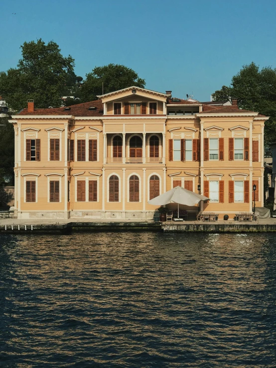 an old yellow brick building is on the water