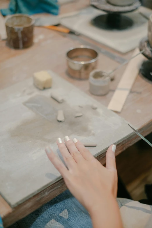 someone doing crafts on a large wooden table