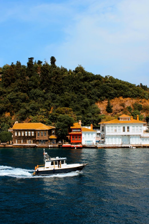 a large boat traveling across a lake surrounded by trees